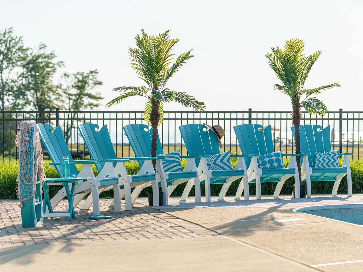 Six turquoise and white poly Adirondack chairs lined up beside a swimming pool
